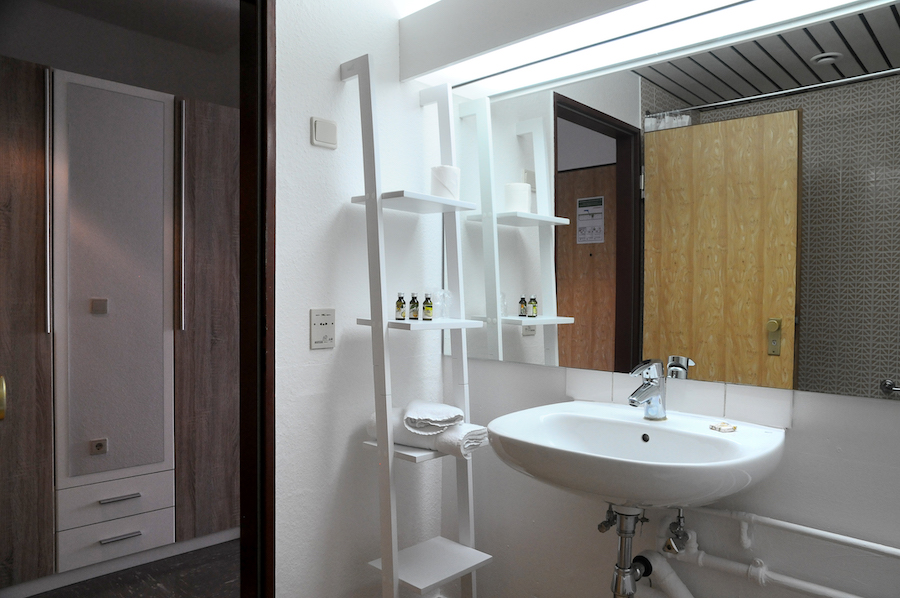 Waschbecken mit Spiegel und Pflegeprodukte im Bad des Classic Apartment auf Zeit