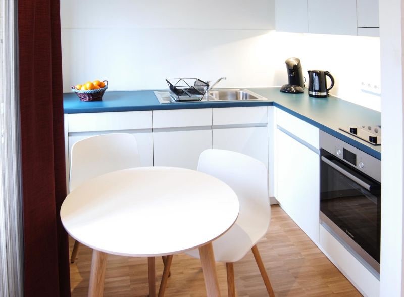 Runder Esstisch mit Stühlen in der Küche des Premium Comfort Apartments Karlsruhe