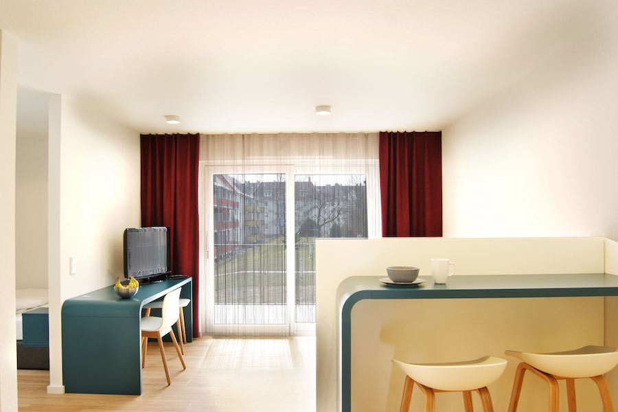 Wohnbereich des Premium Apartments Karlsruhe mit türkisweißen Wohnelementen